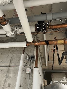 Eddy metering on overhead copper mains in a plant room.