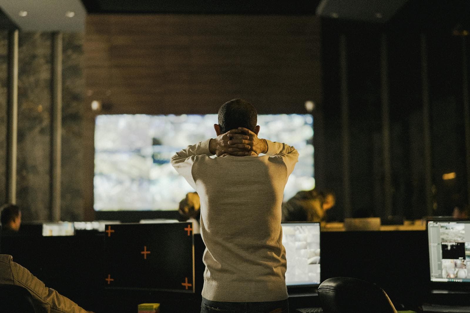 Operator watching monitoring screens in a control room.